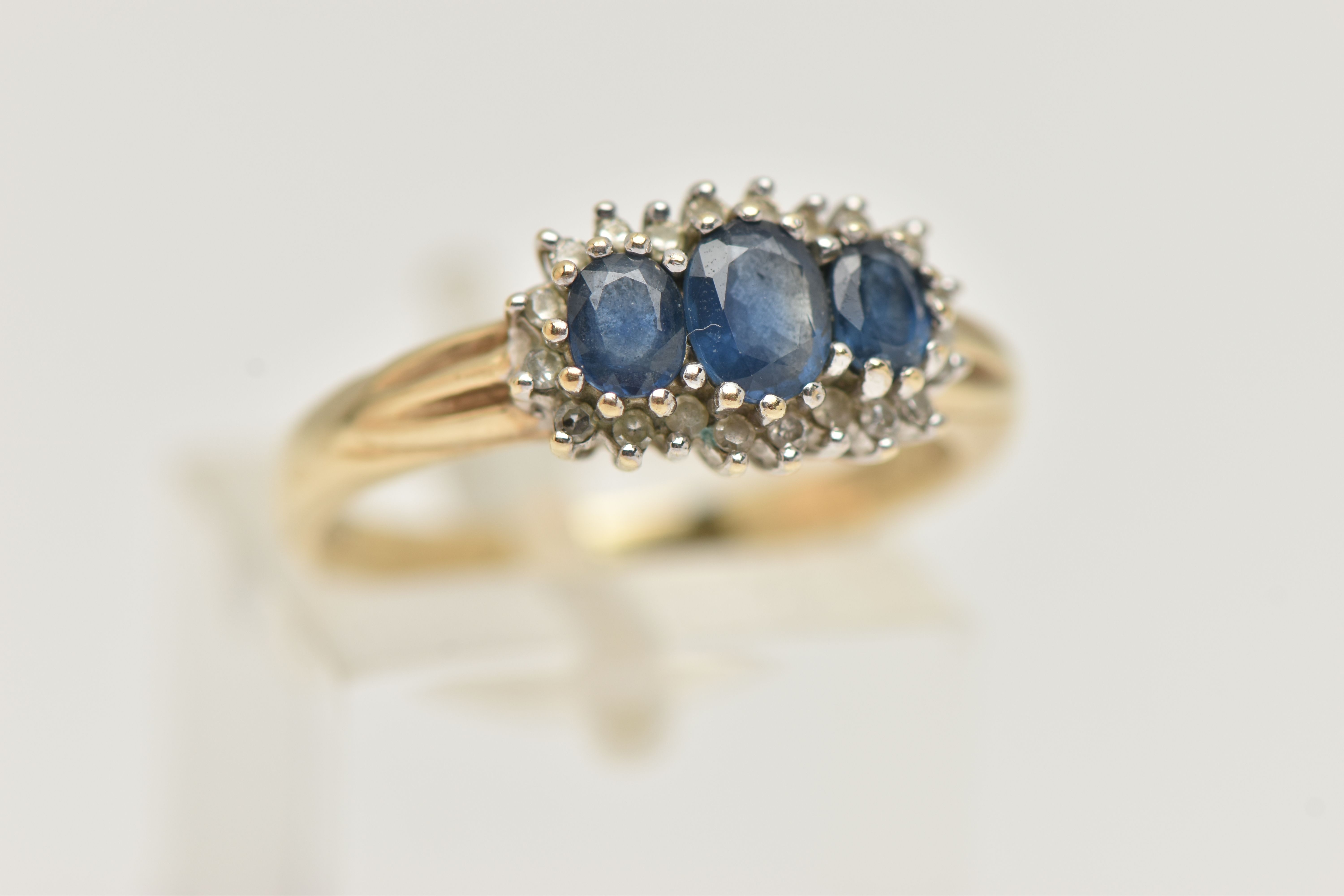 A 9CT GOLD SAPPHIRE AND DIAMOND RING, designed as three graduated oval sapphires within a single cut - Image 4 of 4