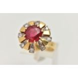 A YELLOW METAL GEM SET DRESS RING, centering on a large circular cut garnet topped red paste