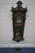 A 20TH CENTURY OAK CASED WALL CLOCK, with a variety of brass decorations, to include masks, ribbons,