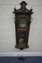 A 20TH CENTURY OAK CASED WALL CLOCK, with a variety of brass decorations, to include masks, ribbons,