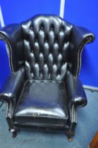 A BLACK LEATHER UPHOLSTERED BUTTONED WINGBACK CHESTERFIELD STYLE ARMCHAIR, width 82cm x depth 75cm x