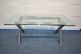 A MODERN GLASS TOP RECTANGULAR TABLE, raised on a cross frame, width 180cm x depth 80cm x height