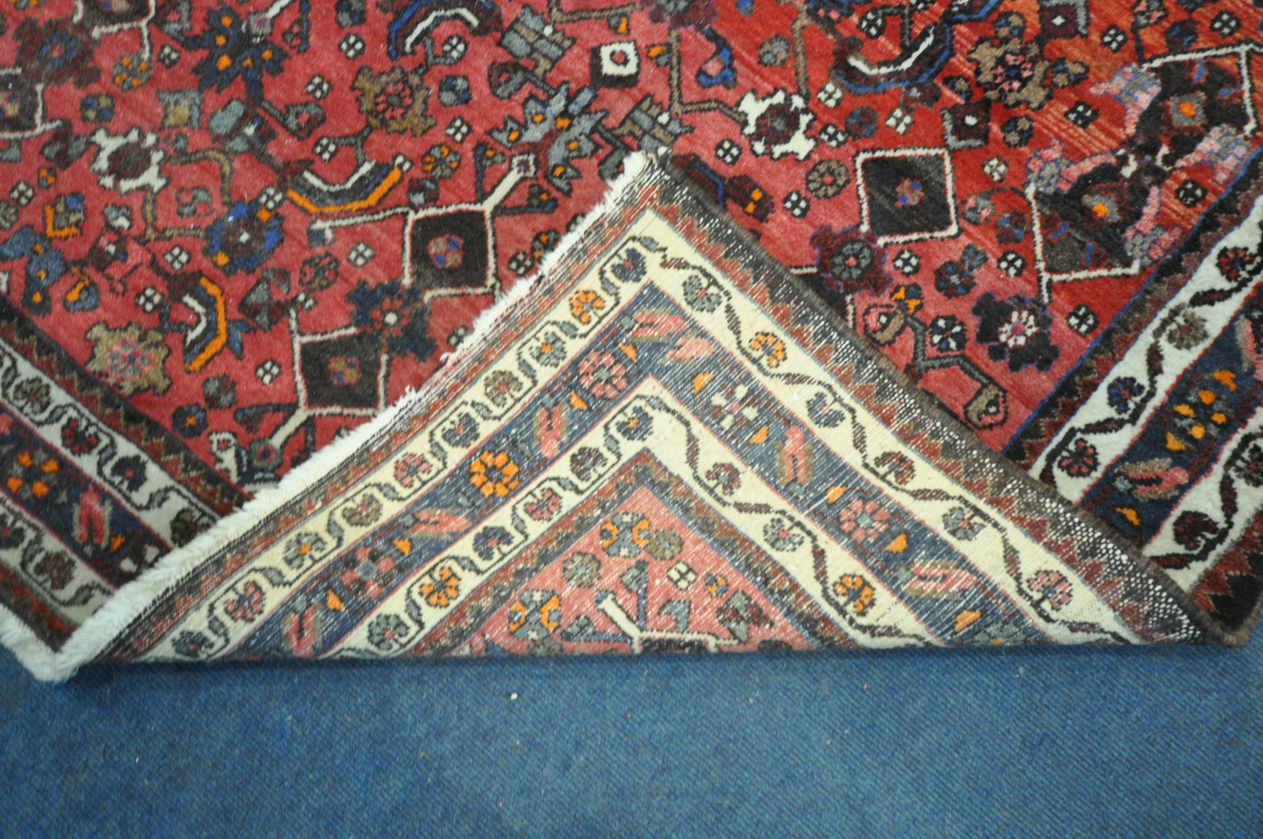 A RED GROUND WOOLLEN RUG, with repeating geometric patterns and multi-strap border, 198cm x 194cm ( - Image 3 of 3