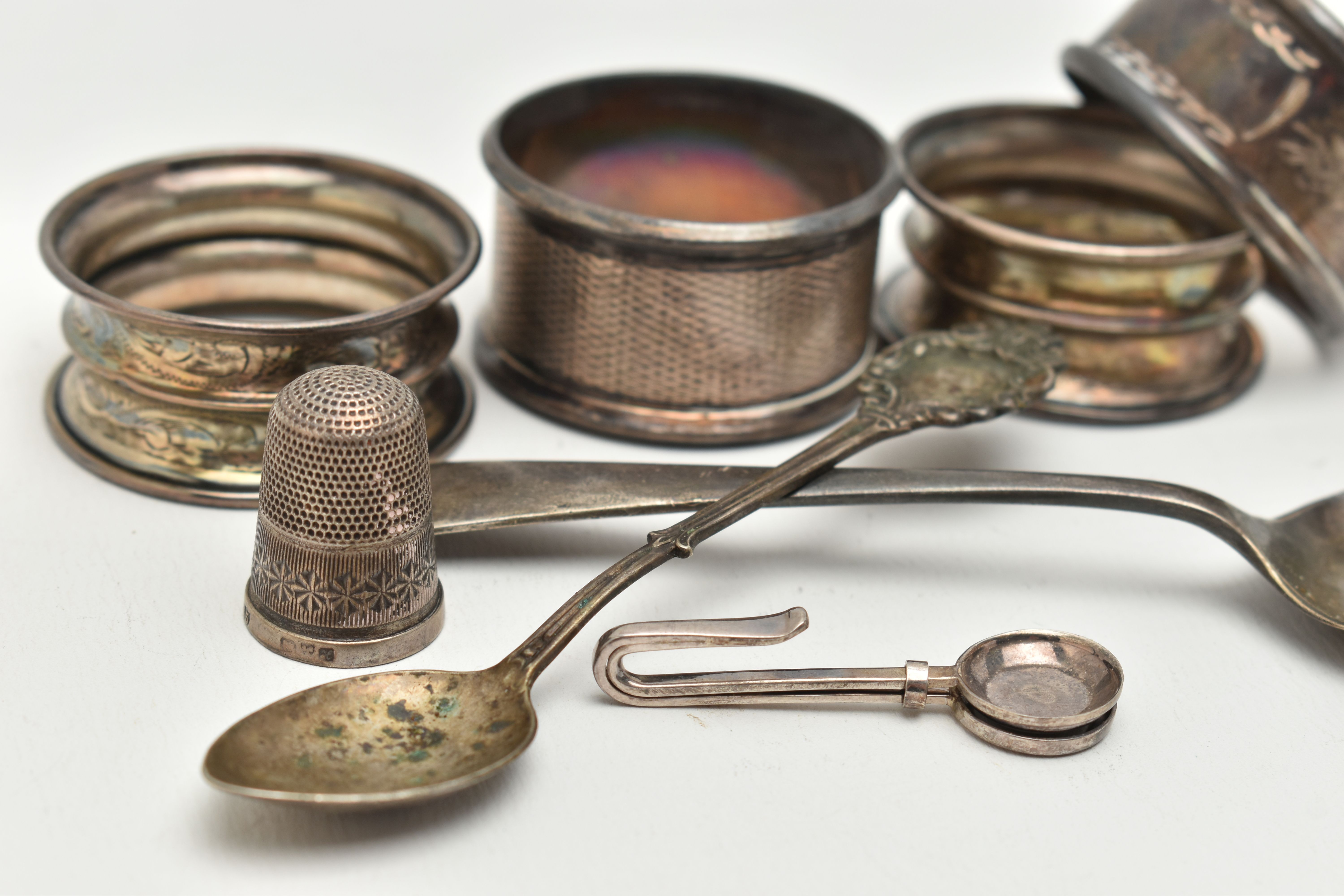 AN ASSORTMENT OF SILVER ITEMS, to include four silver napkin rings, a tea spoon, a spoon a thimble - Image 3 of 3