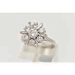 AN 18CT WHITE GOLD DIAMOND CLUSTER RING, centering on a round brilliant cut diamond, estimated