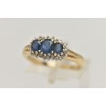 A 9CT GOLD SAPPHIRE AND DIAMOND RING, designed as three graduated oval sapphires within a single cut