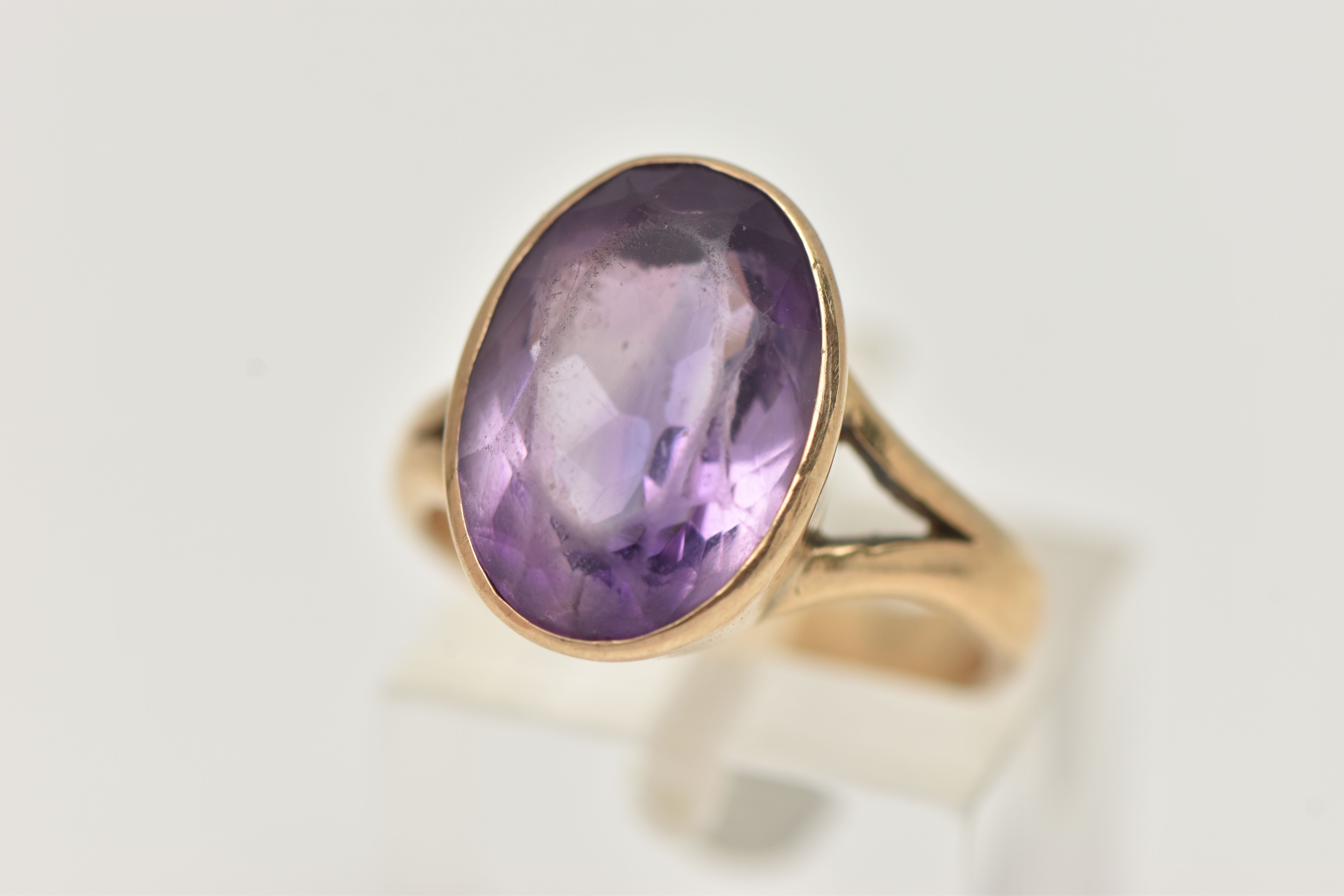 A YELLOW METAL AMETHYST RING, large oval cut amethyst, measuring approximately length 15.2mm x width
