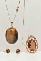 A TIGERS EYE PENDANT NECKLACE AND EARRING SET AND A SMOKY QUARTZ PENDANT, a large oval tigers eye