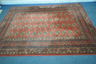 A RED GROUND TABRIZ WOOLLEN RUG, with forty eight central medallions, surrounded by a multi-strap