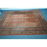 A RED GROUND TABRIZ WOOLLEN RUG, with forty eight central medallions, surrounded by a multi-strap