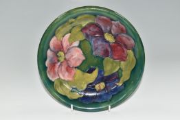 A MOORCROFT POTTERY 'CLEMATIS' DESIGN CABINET PLATE, purple and mauve flowers on a green ground,