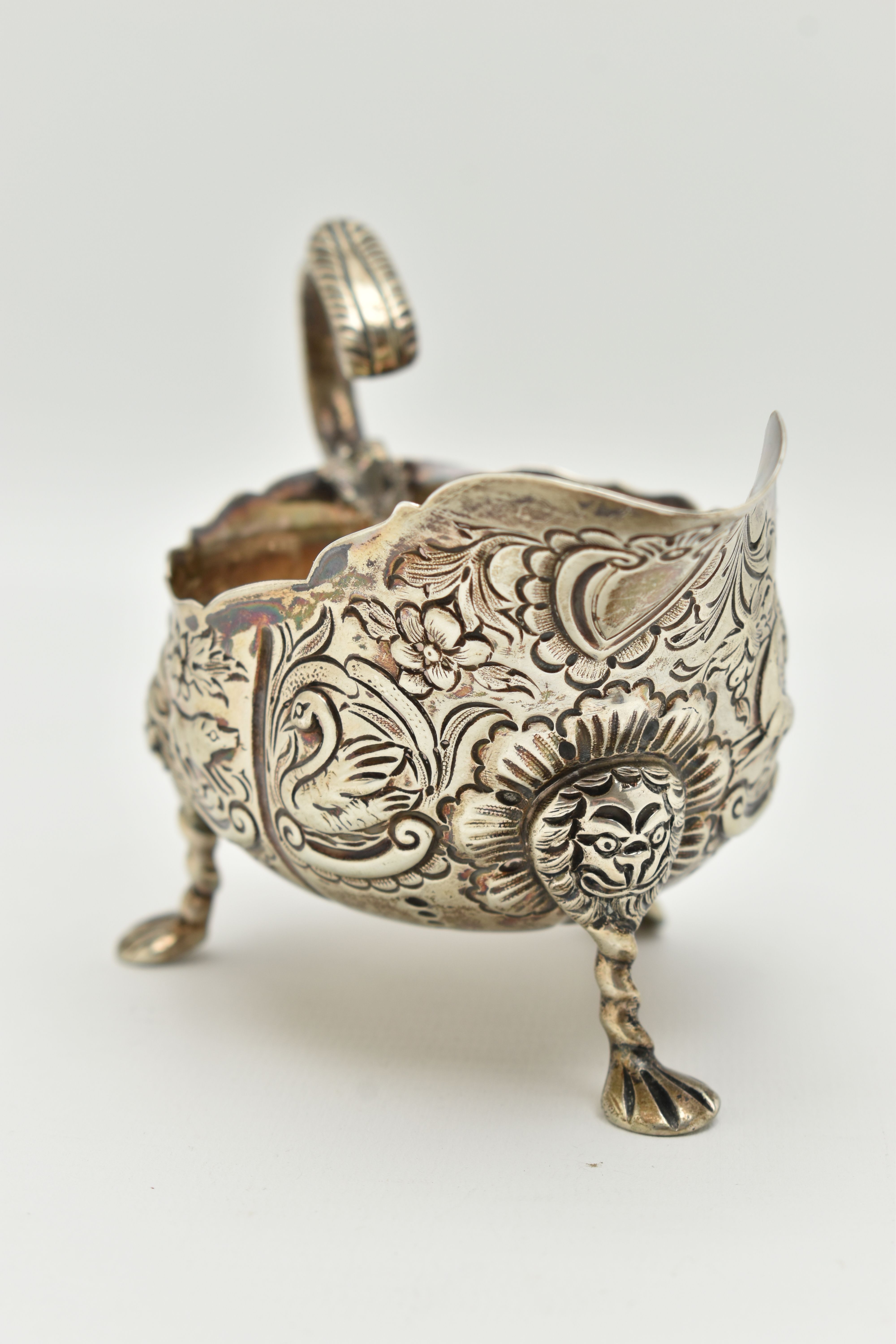 AN IRISH SILVER GRAVY BOAT, early 20th century, embossed animal and floral pattern, with three - Image 2 of 6