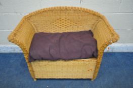 A SMALL RATTAN STORAGE BENCH, with a purple cushion and a hinged lidded seat, width 93cm x depth