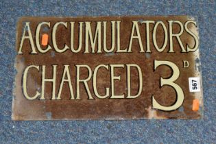 A GLASS WALL MOUNTED SIGN, 'Accumulators Charged 3D', black edged white lettering on brown