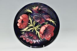 A MOORCROFT POTTERY 'ANEMONE' DESIGN CABINET PLATE, purple and mauve Anemone on a dark blue