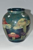A MOORCROFT POTTERY 'CLAREMONT' DESIGN VASE, a red, green and purple mushroom design on a blue/green