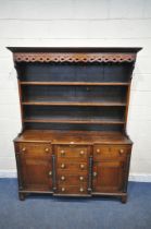 A GEORGIAN OAK BREAKFRONT DRESSER, the top three tier plate rack, with repeating infinity details,