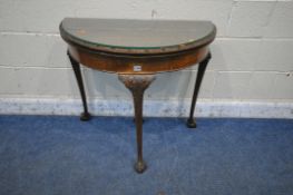 A 20TH CENTURY MAHOGANY DEMI-LUNE FOLD OVER GAMES TABLE, with a glass top protector, enclosing a