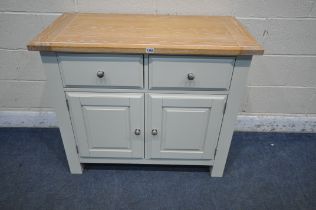 A MODERN LIMED OAK AND CREAM SIDEBOARD, fitted with two drawers, above two cupboard doors, width