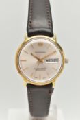 A GENTLEMAN'S BUCHERER WRISTWATCH, the circular face with gold coloured baton markers and hands, day
