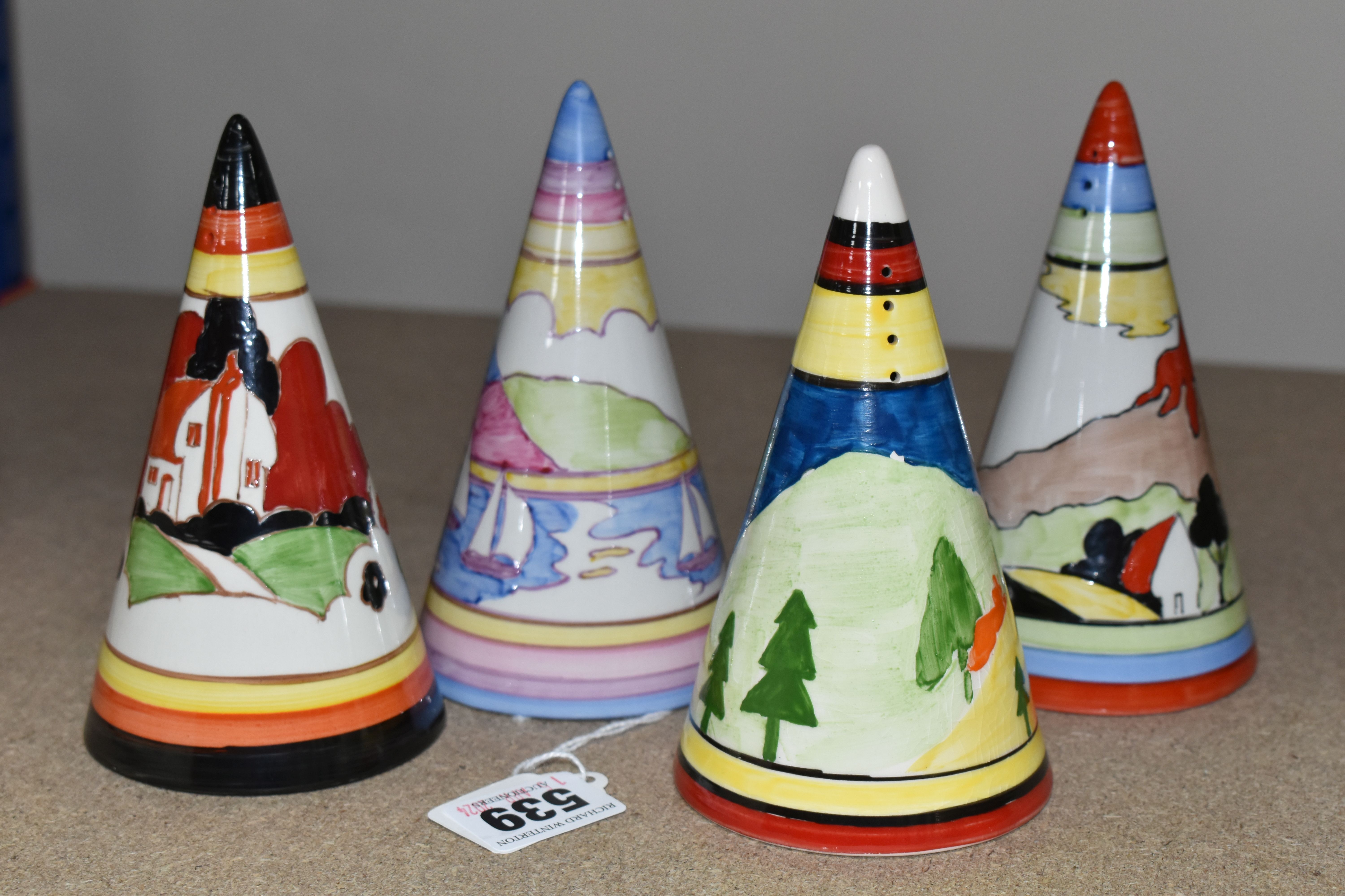 FOUR RENE DALE CONICAL SUGAR SHAKERS, one painted with a castle amongst trees and hills, one with