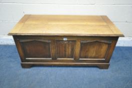 A 20TH CENTURY OAK BLANKET CHEST, with a hinged lid and a single linenfold panel, width 107cm x