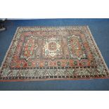 A RED GROUND PERSIAN RUG, with central medallions, repeating geometric patterns and multi-strap