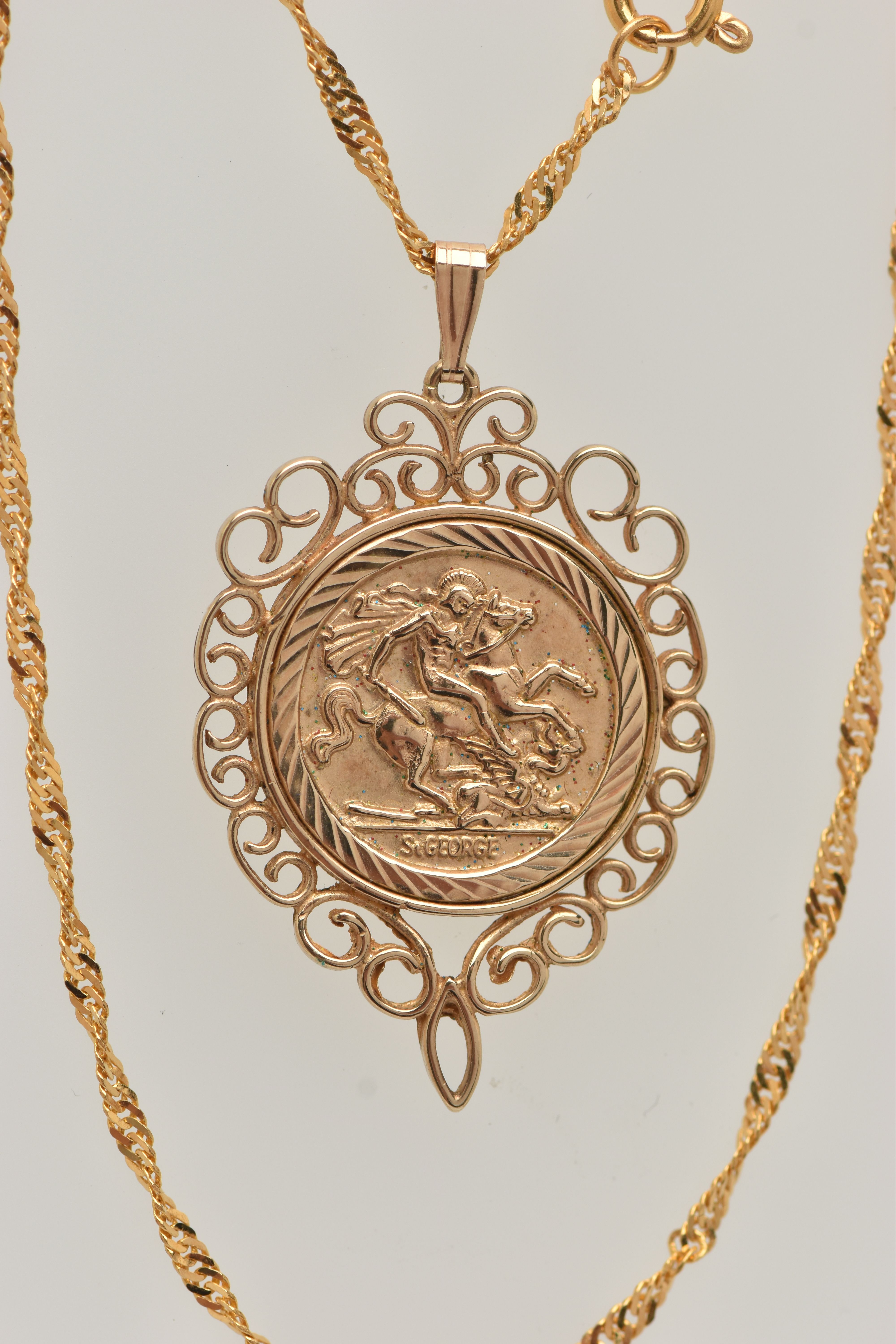 A 9CT GOLD COIN PENDANT, a George and the Dragon disk, with a scrolling open work mount,