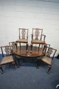 AN EARLY 2OTH CENTURY MAHOGANY OVAL WIND OUT DINING TABLE, the legs with scrolled and foliate