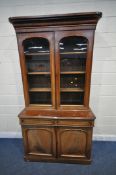 A 19TH CENTURY MAHOGANY BOOKCASE, the top with double glazed doors, that's enclosing three