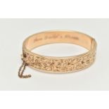 A 9CT ROLLED GOLD HINGED BANGLE, floral detailed bangle, fitted with a push piece clasp with