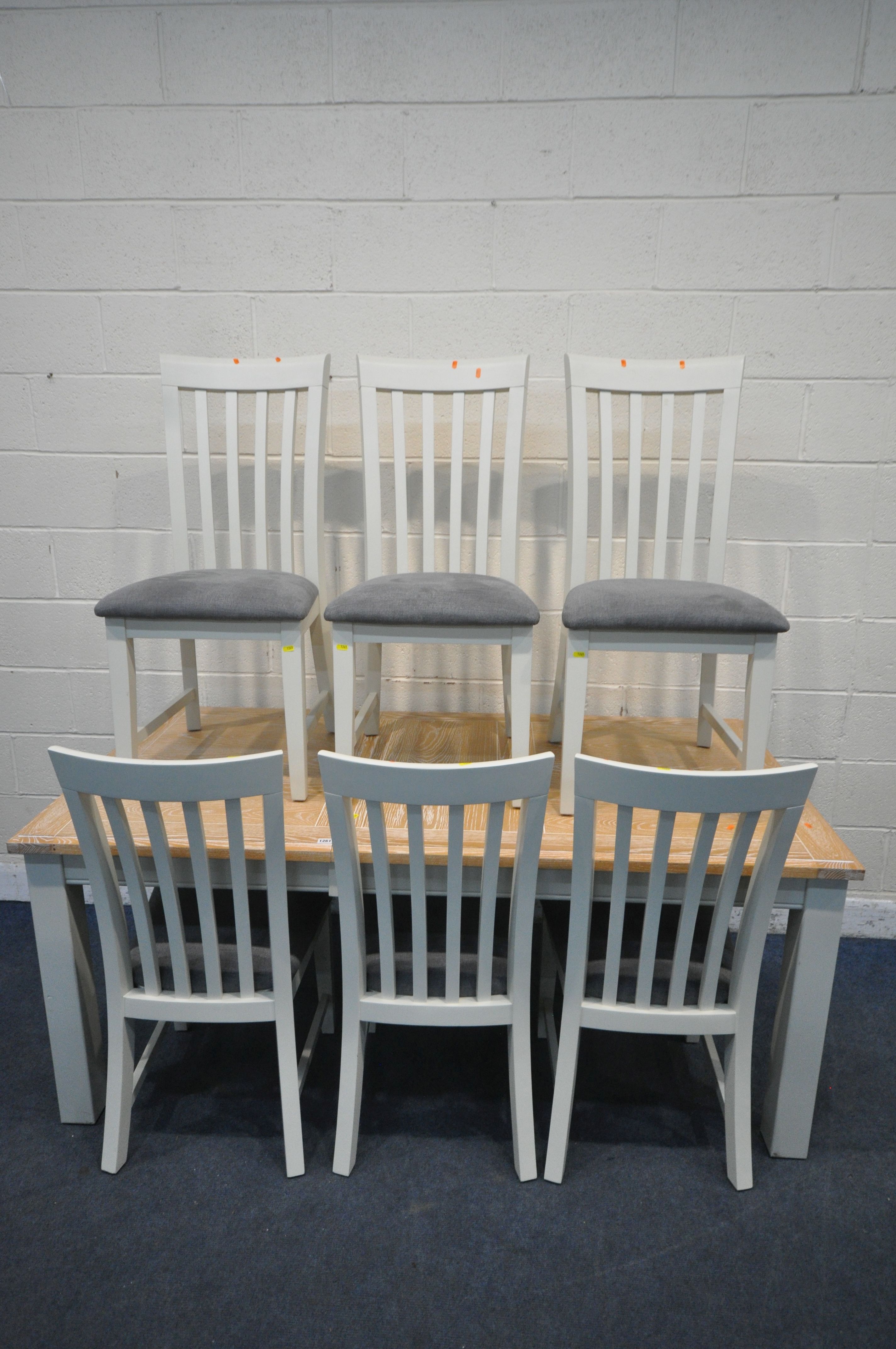 A MODERN LIMED OAK AND CREAM RECTANGULAR EXTENDING DINING TABLE, with one additional leaf,