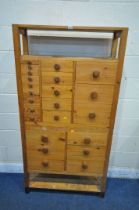 A 20TH CENTURY PINE APOTHECARY CABINET, with an arrangement of twenty-three drawers, the top section