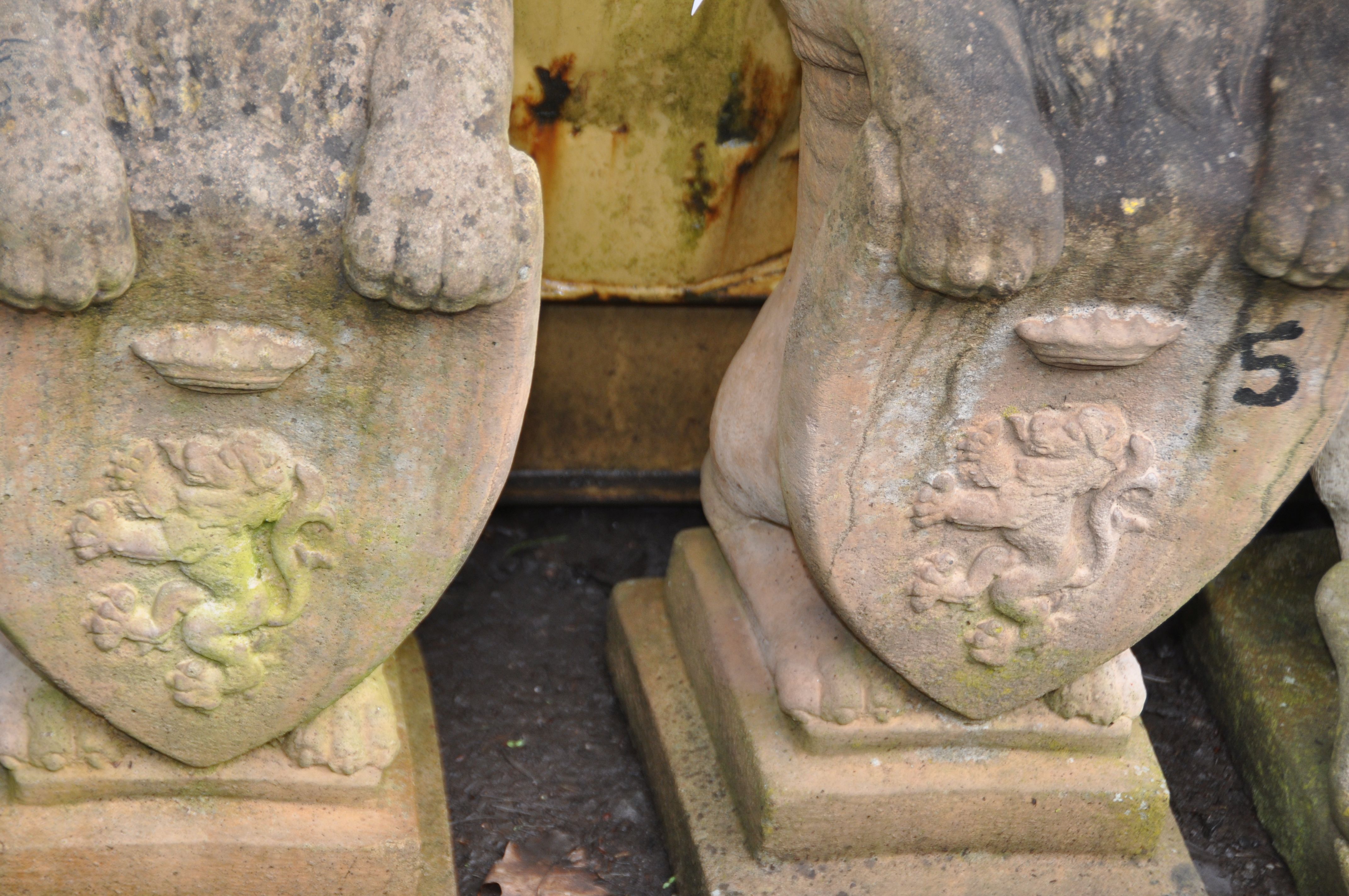 A PAIR OF WEATHERED COMPOSITE GARDEN FIGURES in the form of lion standing on their back legs holding - Image 2 of 3