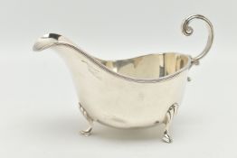 A SILVER GRAVY BOAT, polished form, raised on three hoof feet with shell pattern, and a scroll