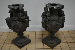 A PAIR OF SECOND HALF 20TH CENTURY WEATHERED BRONZE URNS, cast with two seated putti, two female