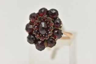 A GARNET CLUSTER RING, the early 20th century cluster set with faceted garnets, to the later mid