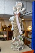 A ROYAL DUX PORCELAIN SCULPTURE OF A FEMALE FIGURE, she is carrying a mandolin across her back, pink