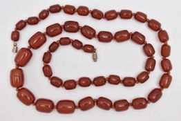 A BAKELITE CHERRY AMBER BEAD NECKLACE, a single strand of rectangular oval beads, largest bead
