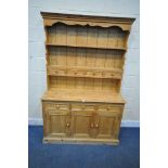 A 20TH CENTURY PINE DRESSER, the top two tier plate rack, fitted with four drawers, atop a base with