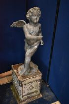A SECOND HALF 20TH CENTURY WEATHERED BRONZE FIGURE OF CHERUB POSED HOLDING A HORN, on a naturalistic