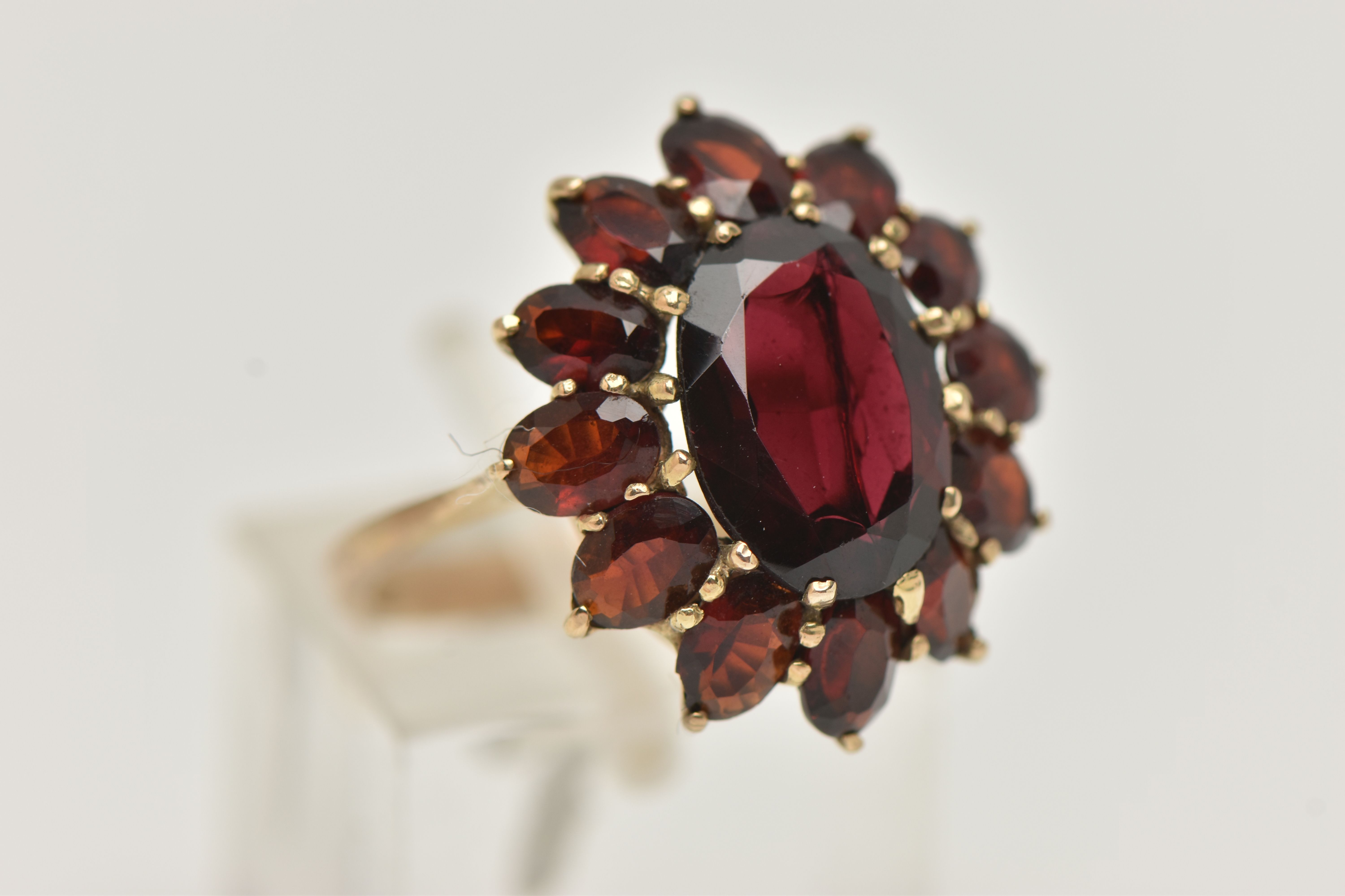 A GARNET CLUSTER RING, designed as a central oval garnet within an oval garnet surround, in claw - Image 4 of 4