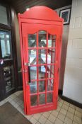 A BESPOKE RED PAINTED PINE TELEPHONE BOX, with a single swing door, glass front and sides, panel