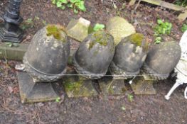 A COLLECTION OF FIVE ACORN SHAPED GATE POST FINIALS with tapered square feet (four cemented together