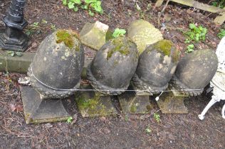 A COLLECTION OF FIVE ACORN SHAPED GATE POST FINIALS with tapered square feet (four cemented together