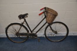 A VINTAGE RALEIGH LADIES BIKE (IDEAL FOR RESTORATION) with basket to front and a distressed