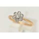A YELLOW AND WHITE METAL DIAMOND FLOWER RING, white metal flower head set with seven small single