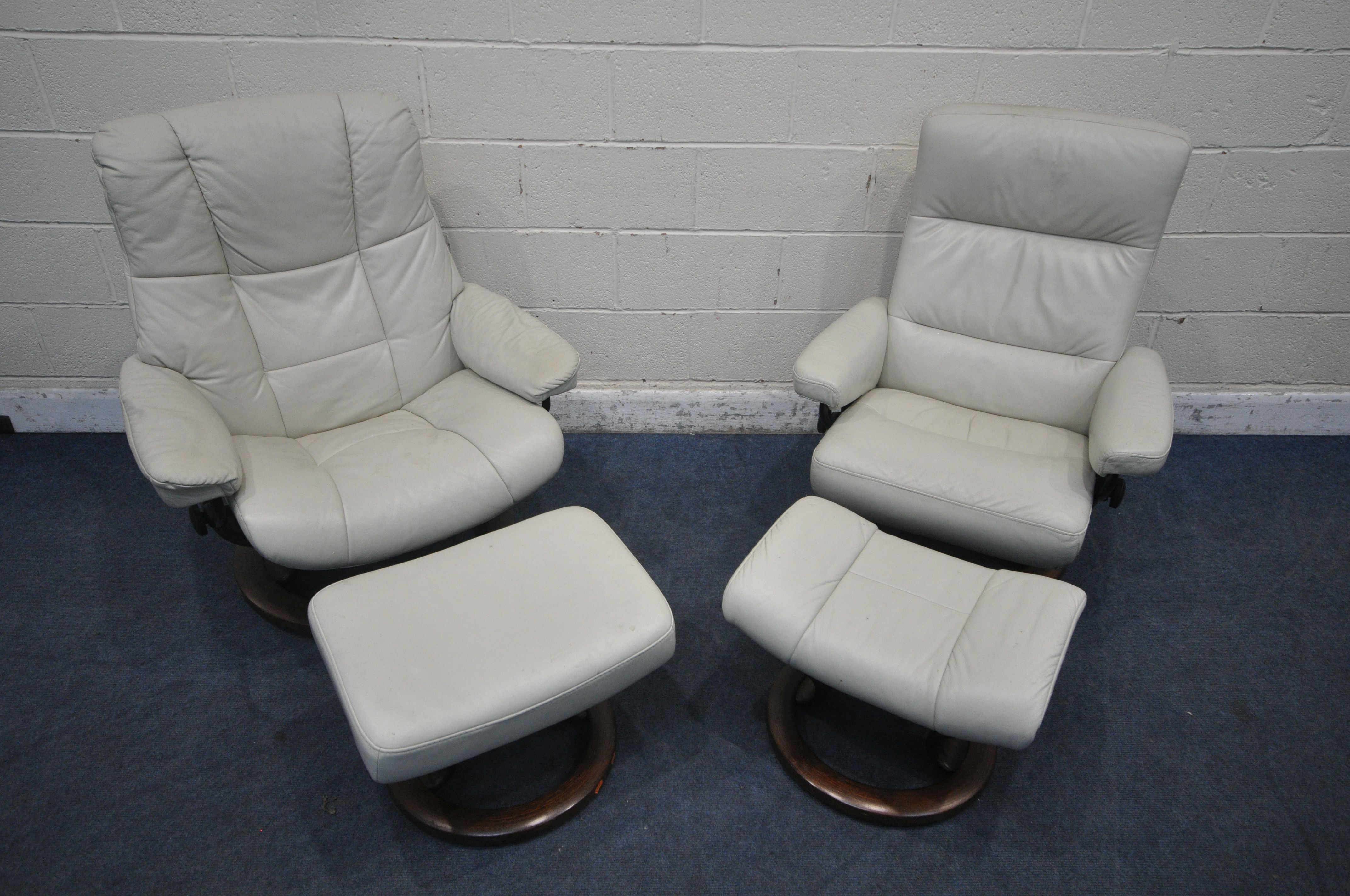 TWO SIZED EKORNES STRESSLESS CREAM LEATHER ARMCHAIRS, along with a pair of footstools (condition
