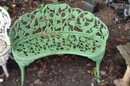 AN EARLY 20TH CENTURY PAINTED CAST IRON CURVED GARDEN SEAT for two with pierced foliate detail to