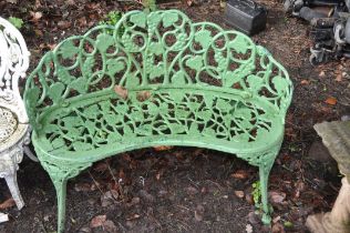 AN EARLY 20TH CENTURY PAINTED CAST IRON CURVED GARDEN SEAT for two with pierced foliate detail to